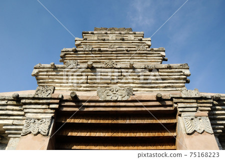 JOGJAKARTA, INDONESIA -JUNE 12, 2014: Entrance arch at old Masjid Besar Mataram Kotagede, Jogjakarta Indonesia. The arch was made from brick and hand made carving stone in traditional Balinese Style 75168223