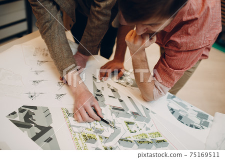 Architect with blueprints and layout design project at office Architect with blueprints and layout design project at office 75169511