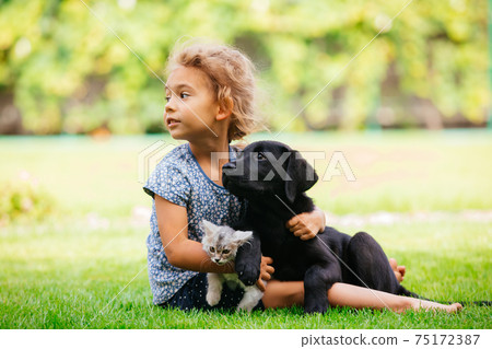 Pets giving their love to small children 75172387