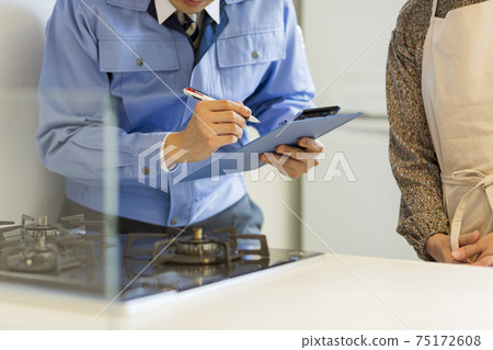 一個穿著工作服的人檢查燃氣灶 一個穿著工作服的人檢查燃氣灶 75172608