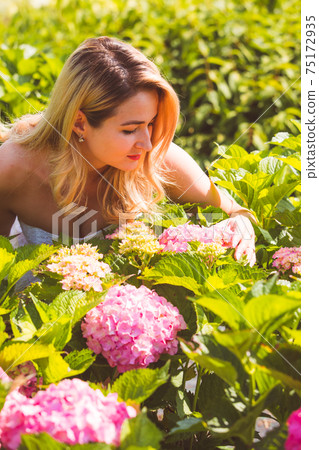 Woman posing outdoors at flowers market between hydrangea flowers 75172935