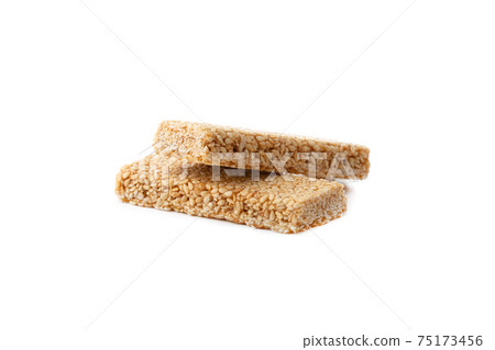 Kozinaki on a white background. Sesame in caramel close-up. Eastern sweetness. Kozinaki on a white background. Sesame in caramel close-up. Eastern sweetness. 75173456