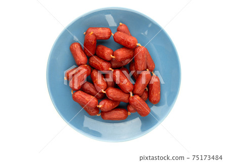 Small smoked sausages on a white background. Grilled sausages close-up on a plate. Top view. 75173484