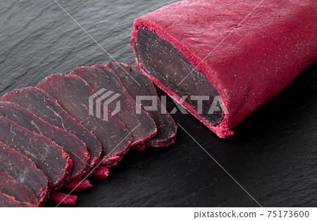 Cured meat on a slate board. Close-up of basturma sliced into pieces. Cured meat on a slate board. Close-up of basturma sliced into pieces. 75173600
