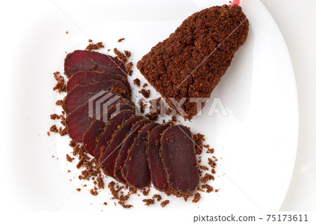 Jerky on a white background. Close-up of basturma sliced into pieces. Jerky on a white background. Close-up of basturma sliced into pieces. 75173611