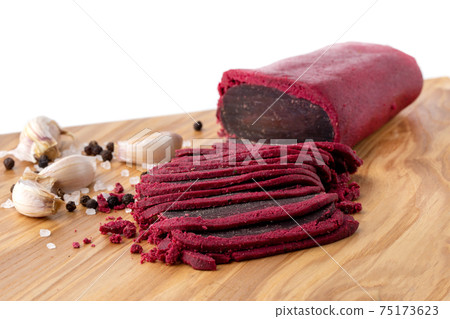 Cured meat on a wooden board. Close-up of basturma sliced into pieces. Cured meat on a wooden board. Close-up of basturma sliced into pieces. 75173623