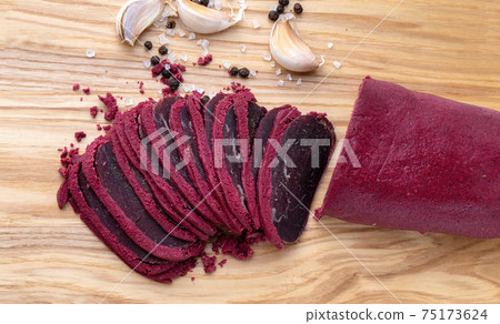 Cured meat on a wooden board. Close-up of basturma sliced into pieces. Cured meat on a wooden board. Close-up of basturma sliced into pieces. 75173624