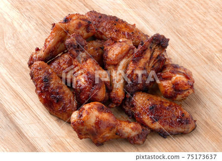 Fried wings close-up. Buffalo wings on a wooden board. Fried wings close-up. Buffalo wings on a wooden board. 75173637