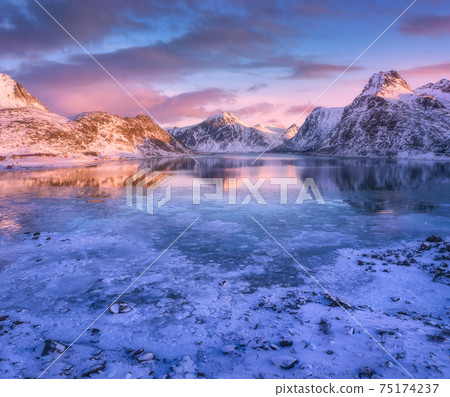 Aerial view of snowy mountains, blue sea with frosty coast 75174237