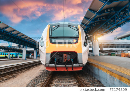 High speed train on the railway station at sunset 75174809