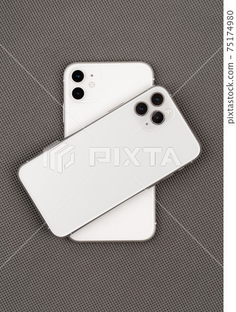 Two smartphones on a gray background. 75174980