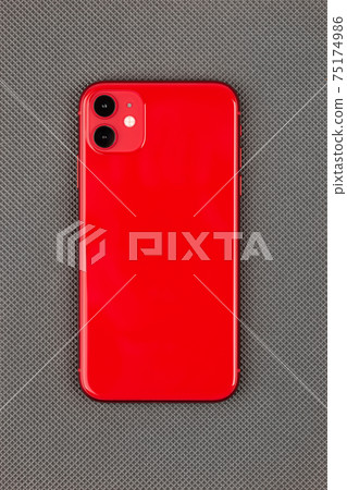 Smartphone on a gray surface. A popular smartphone close-up. 75174986