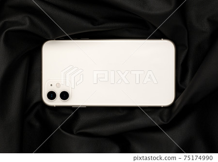 Smartphone with three cameras on black leather fabric. 75174990