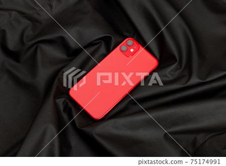 Smartphone with three cameras on black leather fabric. 75174991