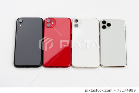 Four smartphones of different colors close-up on a white background. Four smartphones of different colors close-up on a white background. 75174999