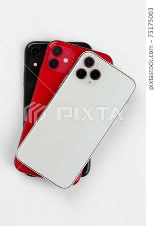 Three smartphones close-up on a white background. Three smartphones close-up on a white background. 75175003