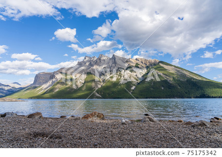 Lake Minnewanka beautiful landscape in summer day. Famous tourist attraction for leisure activities, boat cruise and mountain trail hiking in Banff National Park, Canadian Rockies. Lake Minnewanka beautiful landscape in summer day. Famous tourist attraction for leisure activities, boat cruise and mountain trail hiking in Banff National Park, Canadian Rockies. 75175342