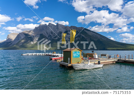Lake Minnewanka beautiful landscape in summer day. Famous tourist attraction for leisure activities, boat cruise and mountain trail hiking in Banff National Park, Canadian Rockies. Lake Minnewanka beautiful landscape in summer day. Famous tourist attraction for leisure activities, boat cruise and mountain trail hiking in Banff National Park, Canadian Rockies. 75175353