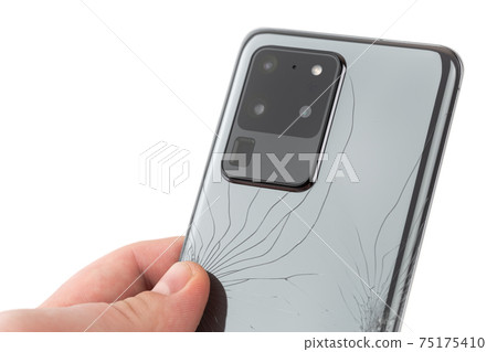 Smartphone with a broken back cover on a white background. 75175410