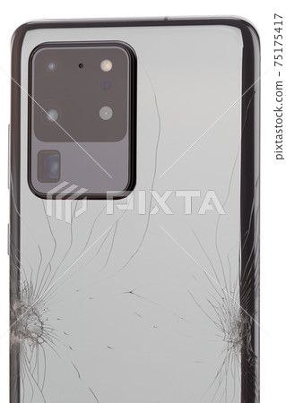 Smartphone with a broken back cover on a white background. Smartphone with a broken back cover on a white background. 75175417