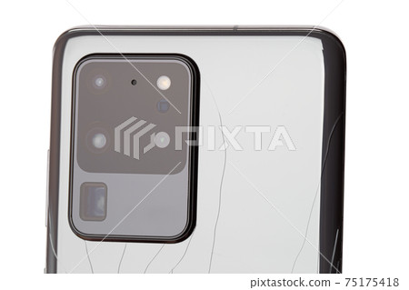 Smartphone with a broken back cover on a white background. 75175418