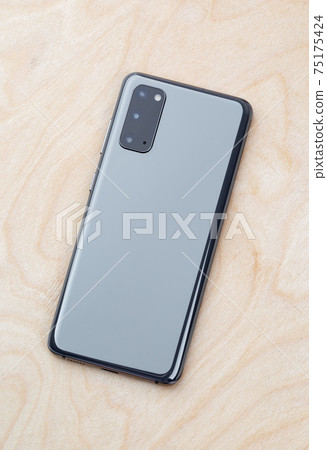 Smartphone on a wooden surface. A popular smartphone close-up. Smartphone on a wooden surface. A popular smartphone close-up. 75175424