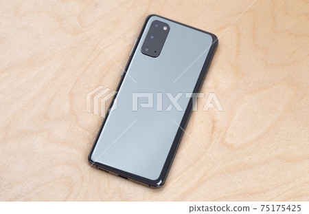 Smartphone on a wooden surface. A popular smartphone close-up. Smartphone on a wooden surface. A popular smartphone close-up. 75175425
