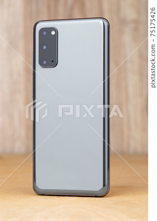 Smartphone on a wooden surface. A popular smartphone close-up. Smartphone on a wooden surface. A popular smartphone close-up. 75175426