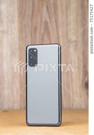 Smartphone on a wooden surface. A popular smartphone close-up. 75175427