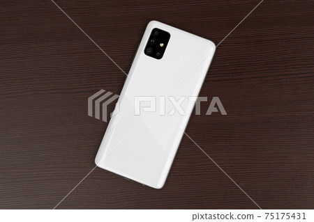 Smartphone on a wooden surface. A popular smartphone close-up. 75175431