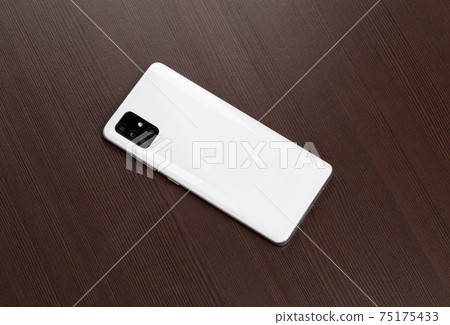 Smartphone on a wooden surface. A popular smartphone close-up. 75175433