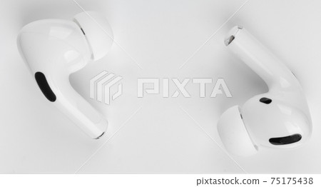 Wireless headphones on a wooden table. Wireless headset and charging case close-up. Wireless headphones on a wooden table. Wireless headset and charging case close-up. 75175438