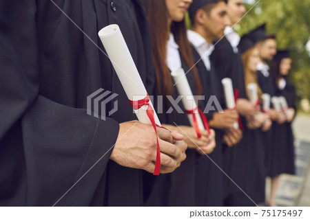 University graduates hands holding diplomas after university graduating University graduates hands holding diplomas after university graduating 75175497