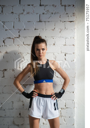 Close up of one young woman wrapping hands with black boxing wraps in gym practice boxing indoor working out fitness female lifestyle Close up of one young woman wrapping hands with black boxing wraps in gym practice boxing indoor working out fitness female lifestyle 75175957