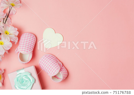 Top view aerial image of decoration Happy mothers day holiday background concept. Flat lay baby shoes and heart shape on modern beautiful pink paper at home office desk. pastel tone creative design. Top view aerial image of decoration Happy mothers day holiday background concept. Flat lay baby shoes and heart shape on modern beautiful pink paper at home office desk. pastel tone creative design. 75176788
