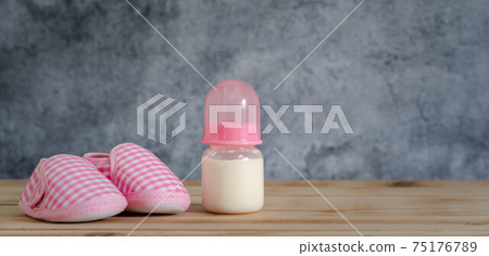Objects on the table of decoration Happy Mother's day holiday background concept. Bottle milk and pink baby shoes. Blur grey color backdrop. Design copy space banner. Mock up infant child of kids. Objects on the table of decoration Happy Mother's day holiday background concept. Bottle milk and pink baby shoes. Blur grey color backdrop. Design copy space banner. Mock up infant child of kids. 75176789
