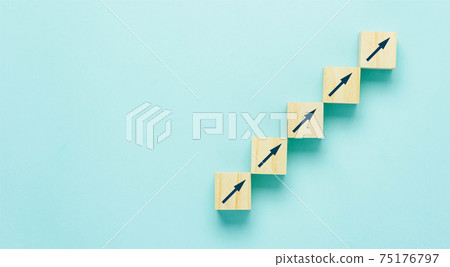 Top view arrow go up on wood block stacking same as step stair on blue paper background, Business growth up concept. copy space for text. Abstract Success stock market . management achievement. Top view arrow go up on wood block stacking same as step stair on blue paper background, Business growth up concept. copy space for text. Abstract Success stock market . management achievement. 75176797