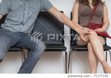 Sexual harassment concept. Man is touching young woman's leg. 75177192
