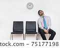Tired and exhausted man is sitting in waiting room on chair. 75177198