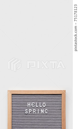 Grey letterboard with season's greeting HELLO SPRING and symbol of Euro currency. Vertical banner with copy space. 75178123
