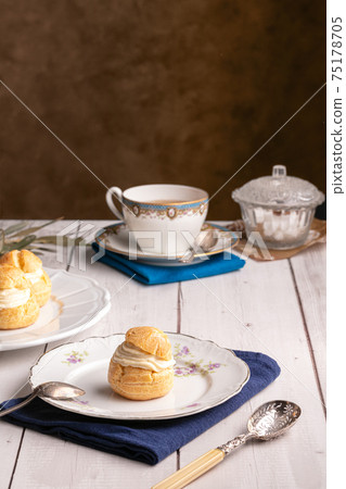 Vanilla cream puffs on a wooden table Vanilla cream puffs on a wooden table 75178705