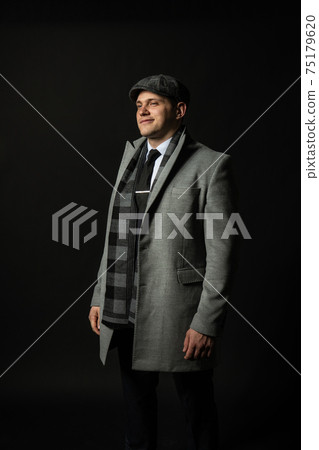 in a coat and a cap a scarf Young male three piece suit business caucasian man, jacket isolated clothing. Happiness content, success elegance background black bodybuilder in a coat and a cap a scarf Young male three piece suit business caucasian man, jacket isolated clothing. Happiness content, success elegance background black bodybuilder 75179620