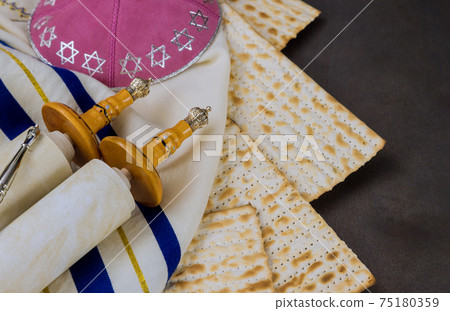 Pesach Jewish traditional celebration with torah scroll and kosher matzah on passover holiday Pesach Jewish traditional celebration with torah scroll and kosher matzah on passover holiday 75180359