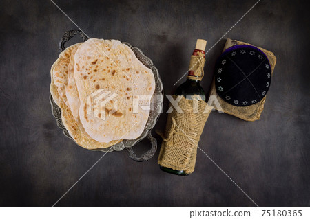 Jewish Passover attributes in composition a cup full of wine and passover matzah 75180365