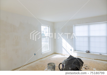 Home remodel of drywall puttying, sealing cracks with gypsum plaster using a spatula. Home remodel of drywall puttying, sealing cracks with gypsum plaster using a spatula. 75180799