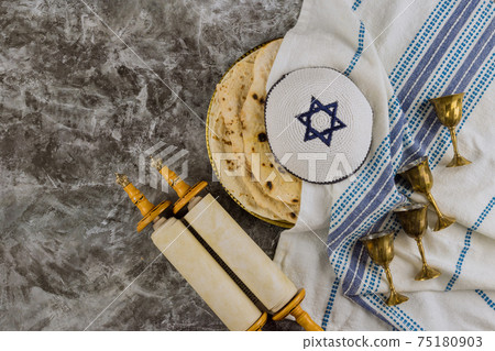 Jewish holiday with holy religious book in the torah scroll, Pesach Israeli matzah bread and four cup for wine Jewish holiday with holy religious book in the torah scroll, Pesach Israeli matzah bread and four cup for wine 75180903