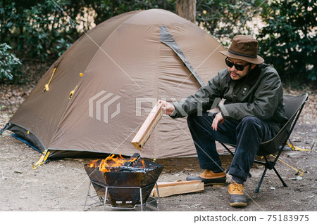 A man bonfire in a solo camp A man bonfire in a solo camp 75183975