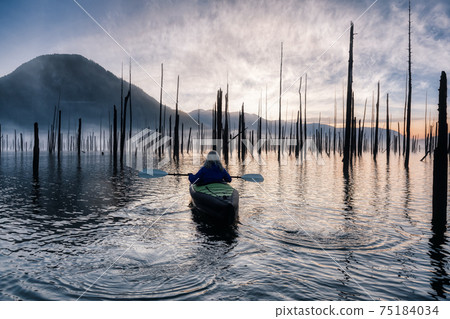 Adventurous Girl kayaking on an infatable kayak in a beautiful lake 75184034