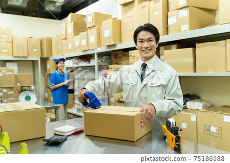 A man packing in a warehouse A man packing in a warehouse 75186988