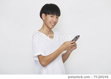 Young Asian man with a mobile phone Young Asian man with a mobile phone 75189248